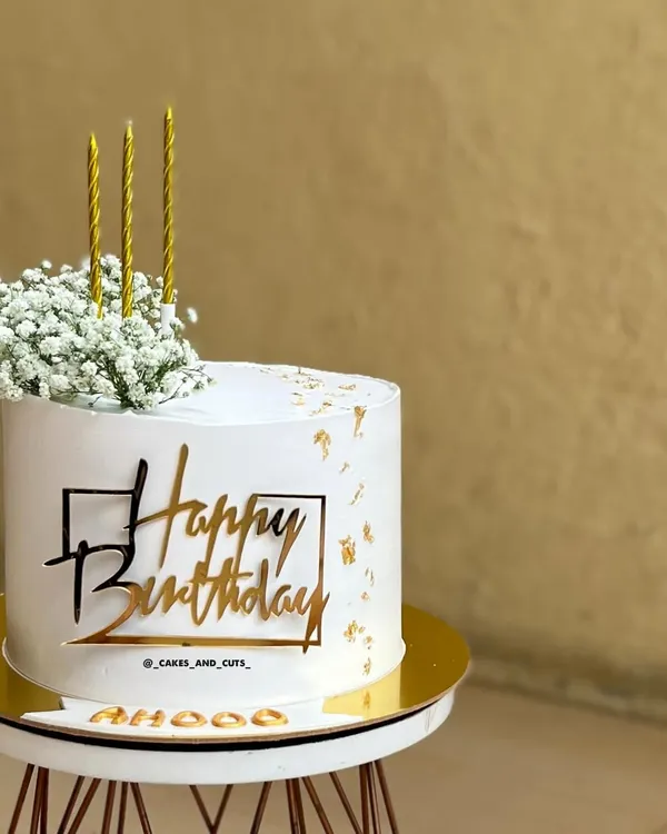 A simply aesthetic birthday cake with a modern gold topper, fresh baby's breath, and delicate gold leaf flakes. This style is very popular and we cover it in our workshops.
