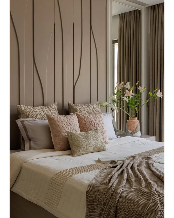 This bedroom from our Santacruz apartment is designed to feel like a gentle exhale. The tone-on-tone palette of warm taupes and blush accents, combined with a full-height textured headboard, creates a space that is calm, grounded, and quietly luxurious.