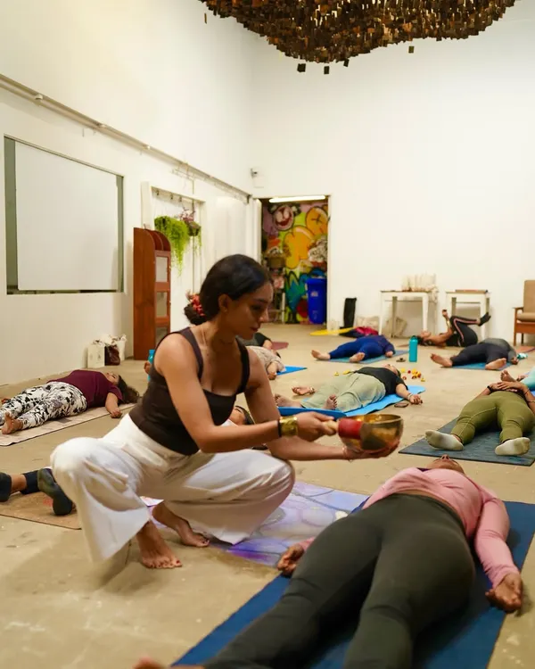 I guide a student into deep relaxation during a Yoga Nidra session, using the gentle vibrations of a singing bowl. This practice is a cornerstone of my teaching, offering a path to release stress and calm the nervous system.