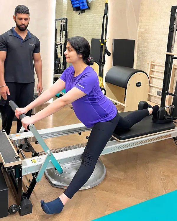 Eight months pregnant and feeling amazing. Our instructor guides this mama to be through a modified lunge on the Reformer, focusing on stability and pelvic floor health.
