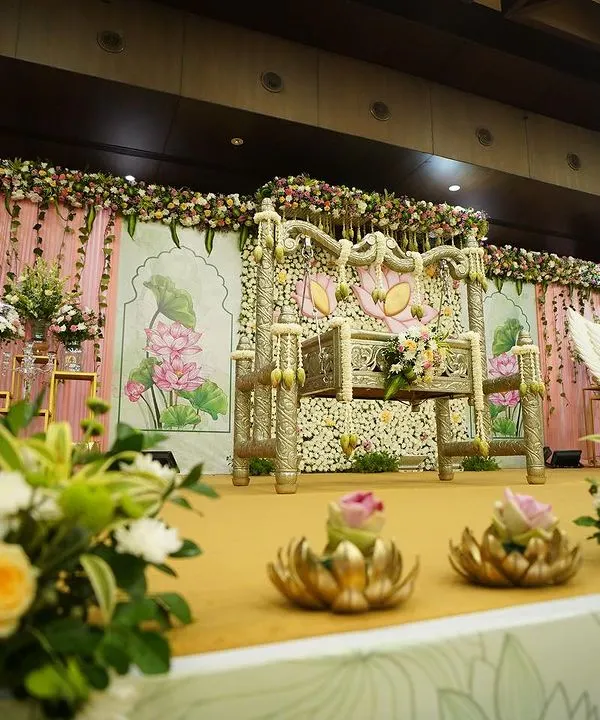 A wide view of our lotus-themed stage for a traditional cradle ceremony. The setup includes a beautifully decorated cradle, a floral wall with painted details, and coordinated props, creating a harmonious and elegant setting.
