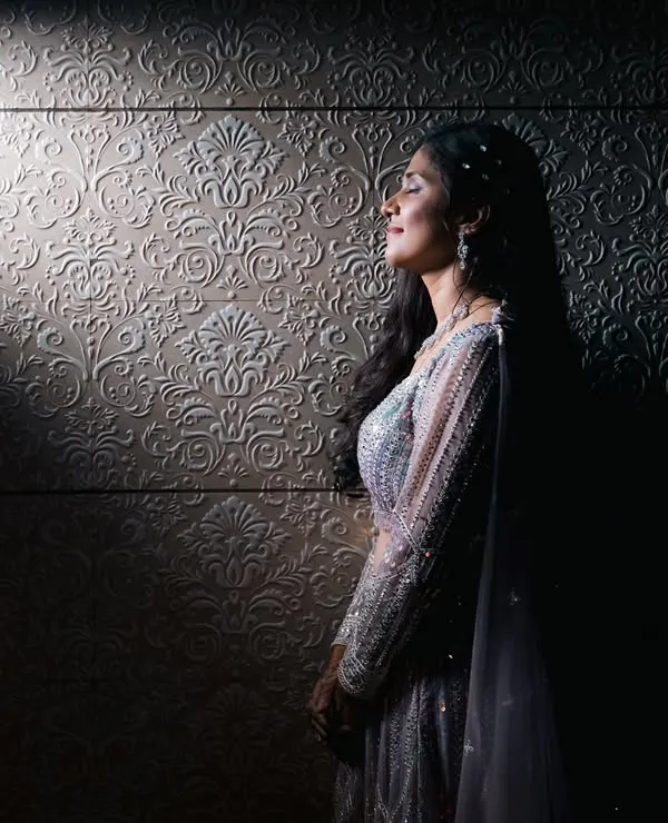 A moment of quiet reflection for the bride. We used a single sliver of light to create this dramatic, artistic portrait that highlights her serene profile and elegant gown.