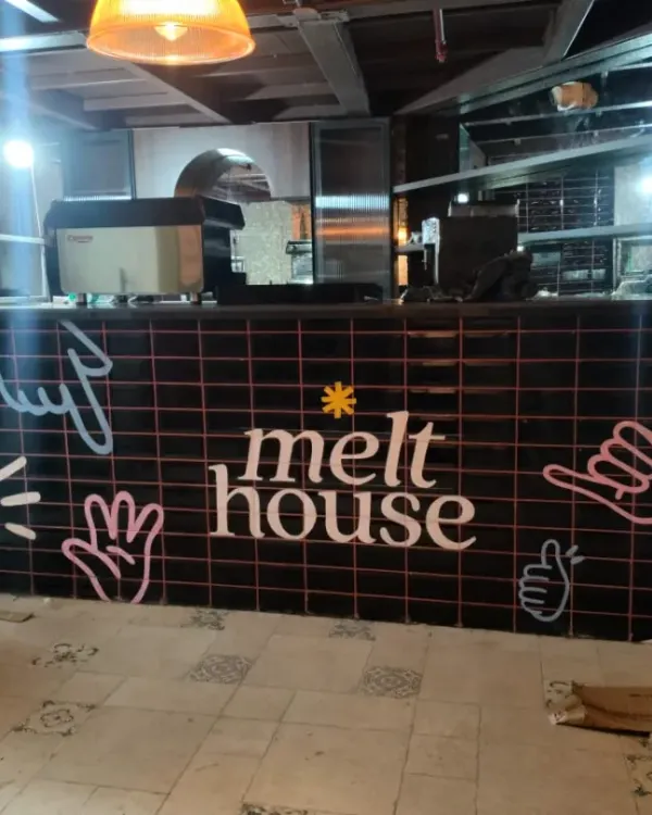 The finished counter at Melt House in Gurgaon, featuring our custom neon-style doodle art. This design adds a cool, modern vibe to the cafe's ordering area, making it instantly inviting.