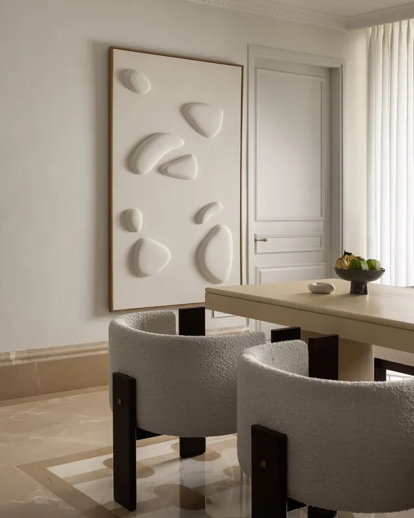 The dining room at Ecru Maison blends calm minimalism with sculptural elegance. We designed a soft-toned dining table and paired it with boucle chairs framed in dark wood for balance and comfort.