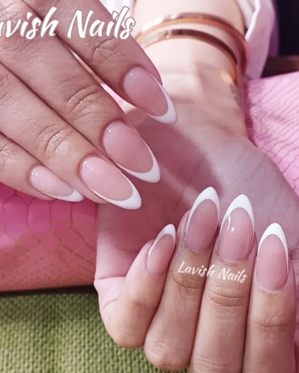 A timeless classic, these long, almond-shaped nails feature a clean and elegant French manicure with crisp white tips on a natural pink base. This look is perfect for a sophisticated, everyday style.