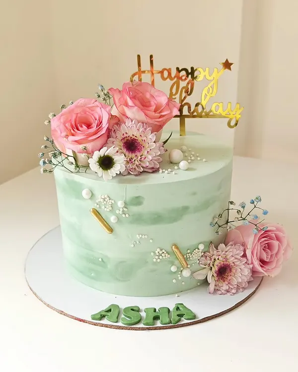 A beautiful mint green cake with a watercolor finish, adorned with fresh pink roses and daisies. This design is a perfect example of how I use fresh flowers to create a soft and elegant look.