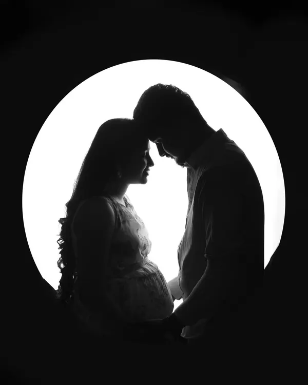 A simple and powerful silhouette of an expecting couple. This artistic black and white portrait focuses on your connection and the beautiful shape of the baby bump, creating a timeless piece of art.