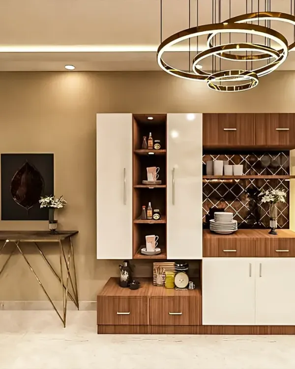 This custom crockery and bar unit is a great example of multi-functional furniture. It combines closed cabinets, open display shelves, and a wine rack, all illuminated by a stunning modern chandelier.