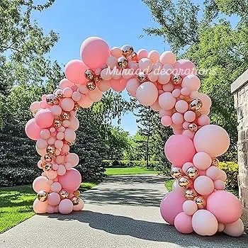A magnificent outdoor balloon arch perfect for welcoming guests to a baby shower or garden party. The dense arch of pink and rose gold balloons creates a grand and festive entrance.