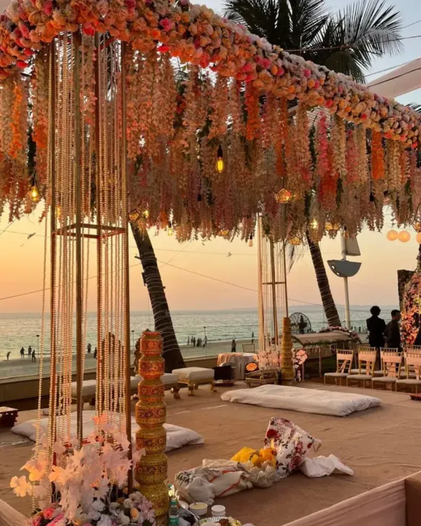 A sunset ceremony with a mandap that feels like a dream. We used cascading floral arrangements and delicate string lights to create this magical setting right on the beach, perfect for a golden hour wedding.