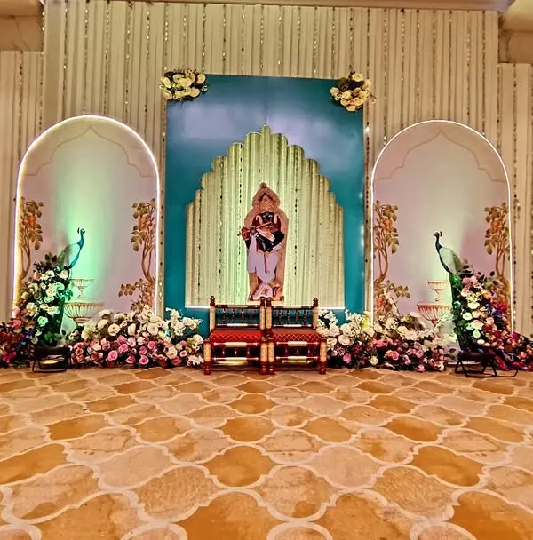A grand stage I designed for a Janmashtami celebration, inspired by traditional Pichwai art. The setup features custom-painted backdrops with Shrinathji, peacock cutouts with floral tails, and elegant arches, creating a divine atmosphere in a large hall.