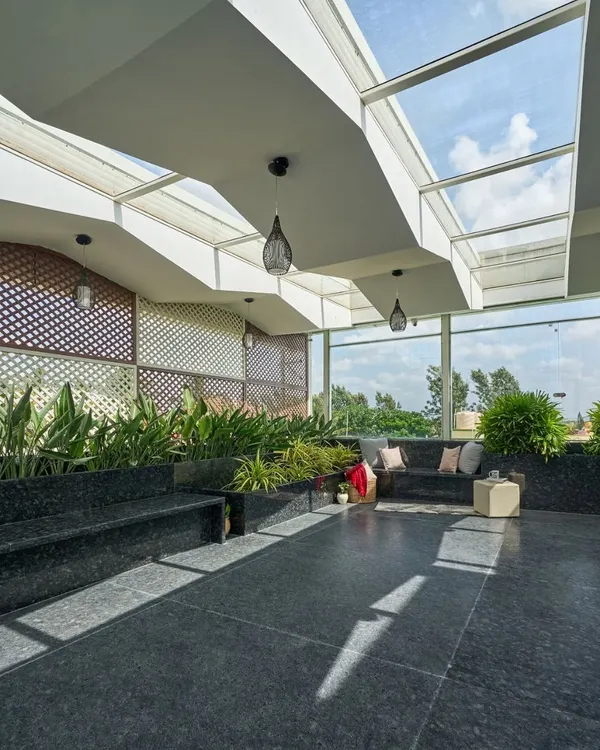 The terrace of the 'Wilasa' villa is a sun-filled atrium designed for relaxation. The skylight roof and extensive planters create a greenhouse effect, making it a perfect space for yoga or quiet contemplation.