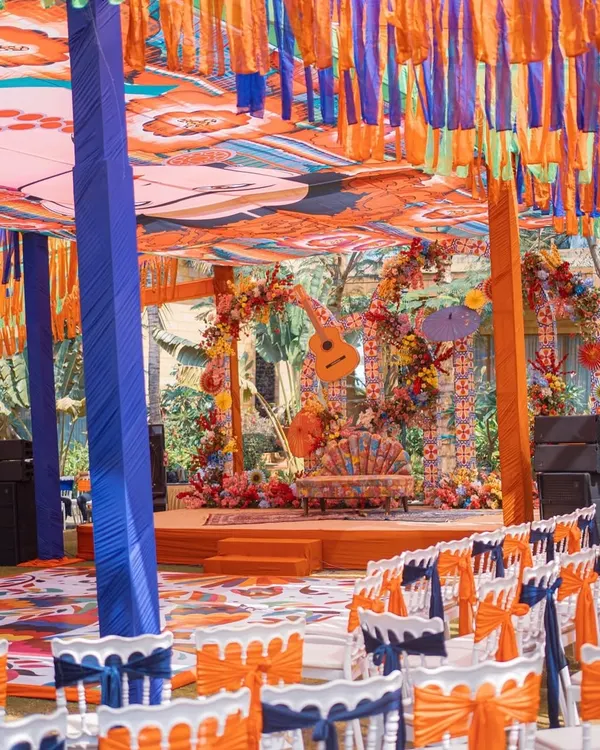 A full view of our Mexican-themed Mehendi setup. The vibrant decor includes a custom printed canopy, colorful tassel draping, and a floral-adorned stage, creating a lively fiesta atmosphere.