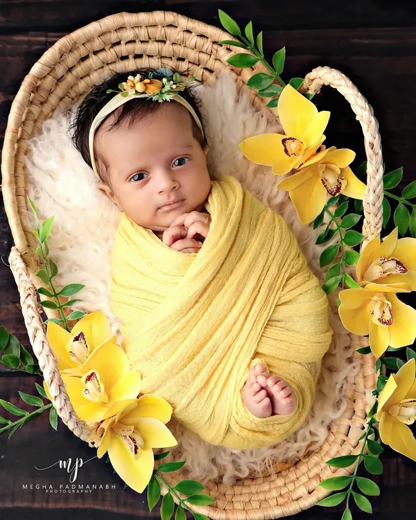 This curious little one is looking right at the camera from her cozy basket. We love capturing both sleepy and awake moments during our newborn sessions.
