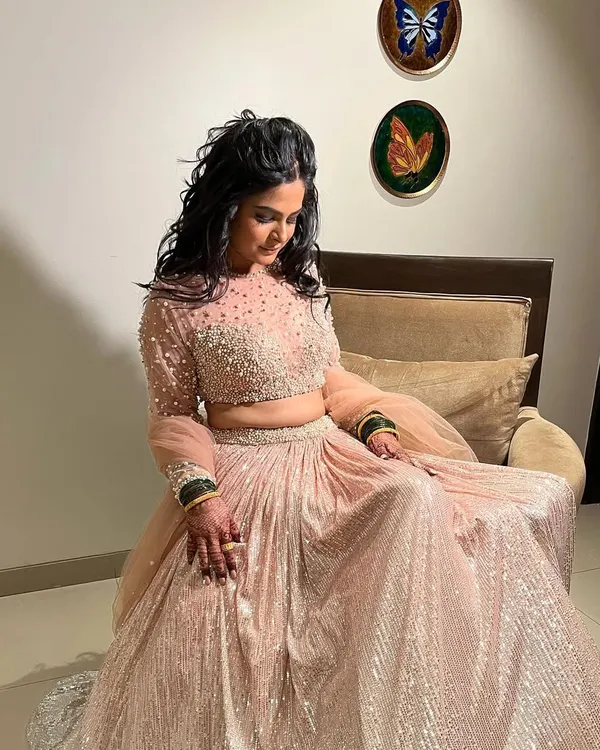 A glamorous Sangeet look for Pradnya. The sparkling lehenga is paired with soft, open curls and dramatic eye makeup, making her look like a princess.