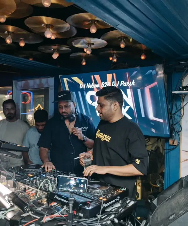 In discussion with DJ Nelson during our back to back set. We're coordinating the next sequence of tracks to keep the energy building.