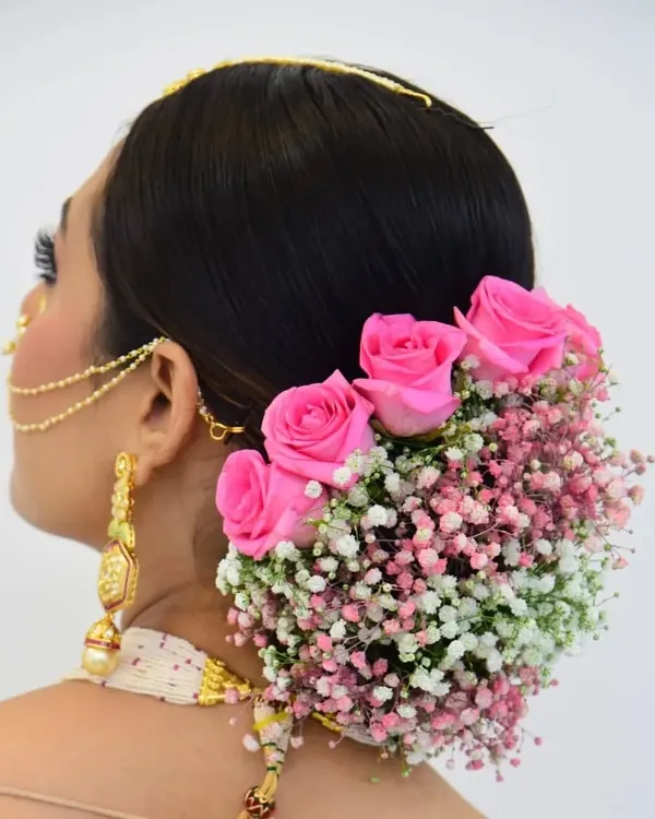 My popular floral bun, created with fresh pink roses and baby's breath. This hairstyle is a favorite among brides for its romantic and soft appearance, adding a beautiful, natural element to the overall look.