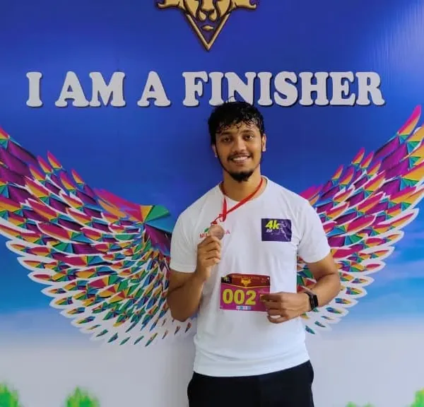 An athlete padrões with his finisher medal at the 4K Human Rights Day Run. We encourage our members to participate in events that promote fitness and a good cause.