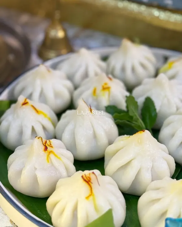 A close up of my classic Ukdiche Modaks, served on a traditional banana leaf. Each one is pleated by hand and garnished with precious saffron strands, just how my Aaji used to make them.