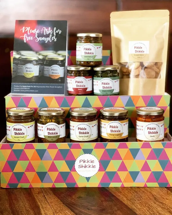 A complete view of our product range, featuring our colourful gift box. You can see our selection of pickles, jams, and a packet of our traditional Punjabi Mathri, perfect for gifting or stocking your pantry.
