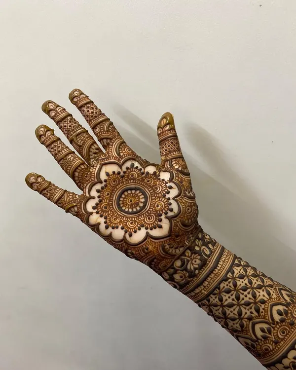 A classic mandala design on the palm, with a scalloped floral border. The details on the fingers complete this elegant look.