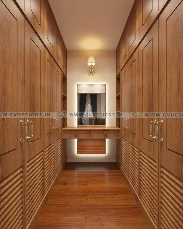 This classic walk-in closet is a teakwood masterpiece. We designed it with louvered doors for ventilation, antique-style handles, and a central dressing unit with a backlit mirror, creating a space of timeless elegance.