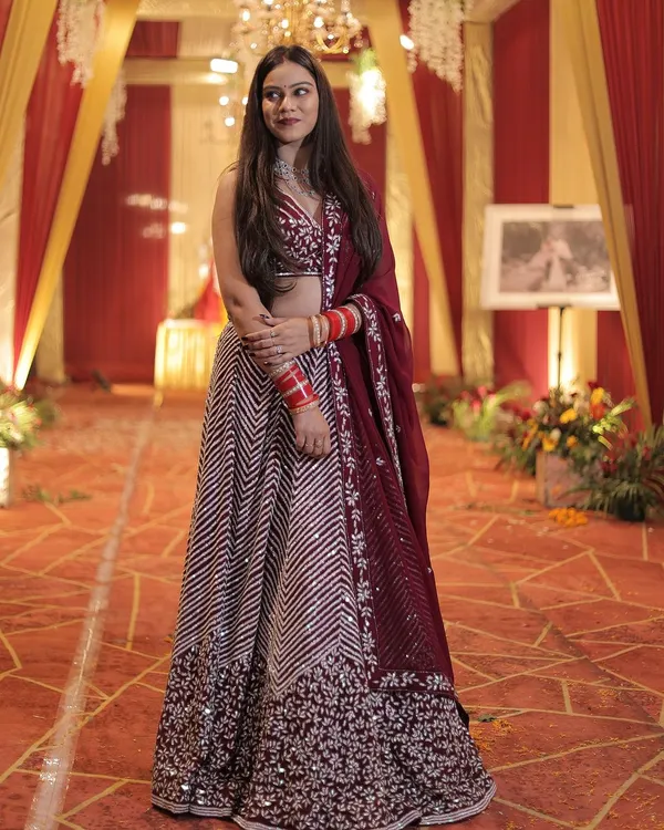 This wine-colored lehenga with chevron embroidery is a sophisticated and stylish choice for a wedding reception or sangeet.