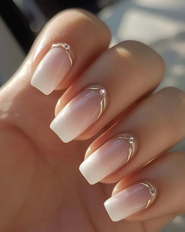 A beautiful example of a reverse French manicure with a soft ombre effect, accented with a delicate silver line and a single rhinestone for a touch of elegance.