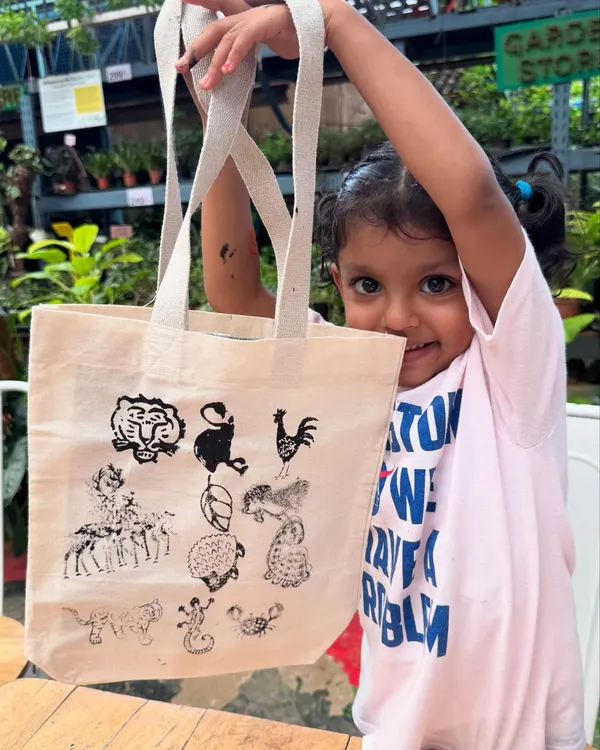 This is what pure joy looks like. A young artist proudly showing off the cotton tote bag she decorated in our block printing workshop. We use safe, non-toxic inks so little hands can create freely, learning about animals and sustainability through play.