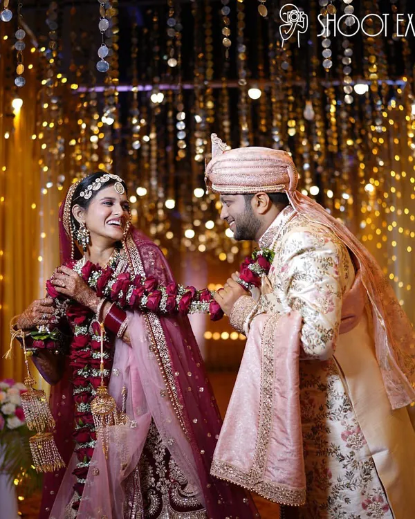 A fairytale moment captured under a canopy of golden lights. We focus on creating magical, candid shots like this one, where the joy of the couple shines through, making for a perfect wedding photograph.