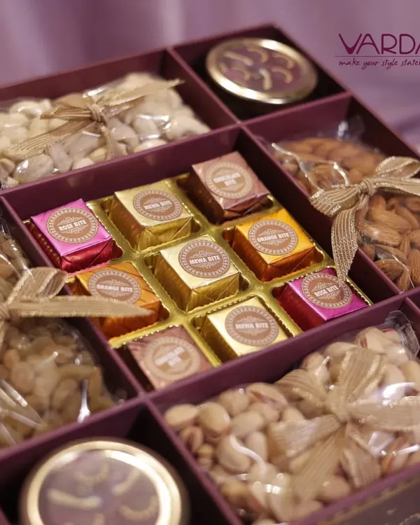 A close-up of a luxury gift hamper, showcasing an assortment of premium dry fruits and foil-wrapped chocolates. Each compartment is carefully arranged to create a visually appealing and delicious gift.