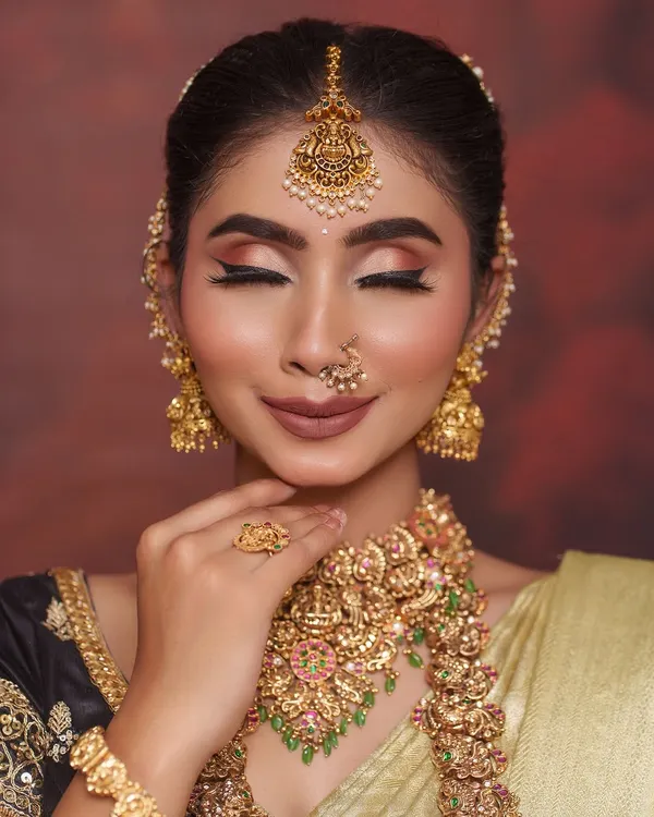 A serene look featuring one of our most popular antique temple jewellery sets. The choker and haram are adorned with Goddess Lakshmi motifs, perfect for bringing blessings to your new beginning.