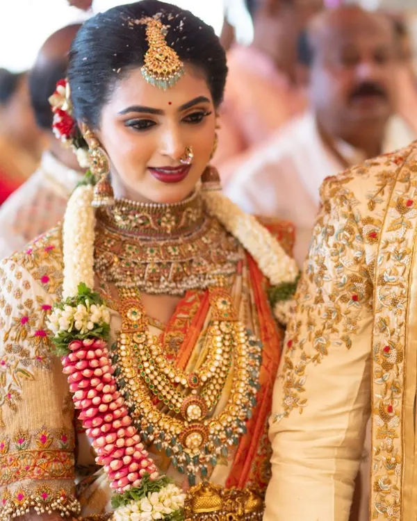 A beautiful candid moment from a wedding ceremony, with our bride looking radiant in her custom embroidered blouse and silk saree. Her traditional gold jewelry and joyful expression perfectly capture the spirit of the day.