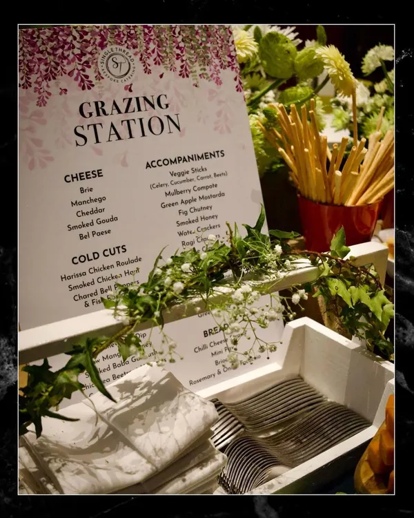 Every detail is considered in a bespoke event. This custom menu for a "Grazing Station" outlines the specific selection of cheeses, cold cuts, breads, and accompaniments, communicating the care and planning behind the spread.