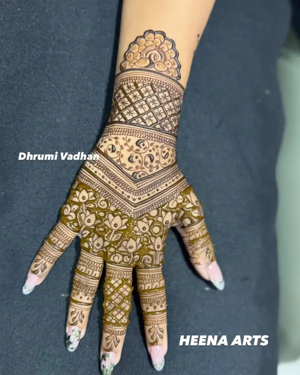 A beautiful example of a modern mehendi design. This piece uses negative space and a combination of floral and geometric patterns for a contemporary look.