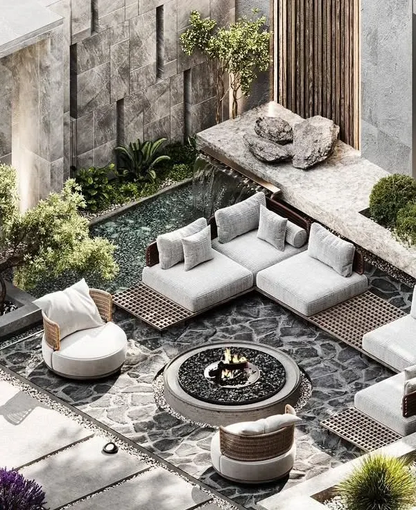 An isometric view of a modern sunken lounge concept, designed for intimate gatherings. This outdoor living space features a central fire pit, custom stone flooring, and integrated planters, all enclosed by a textured stone wall with a gentle water feature for ambient sound.