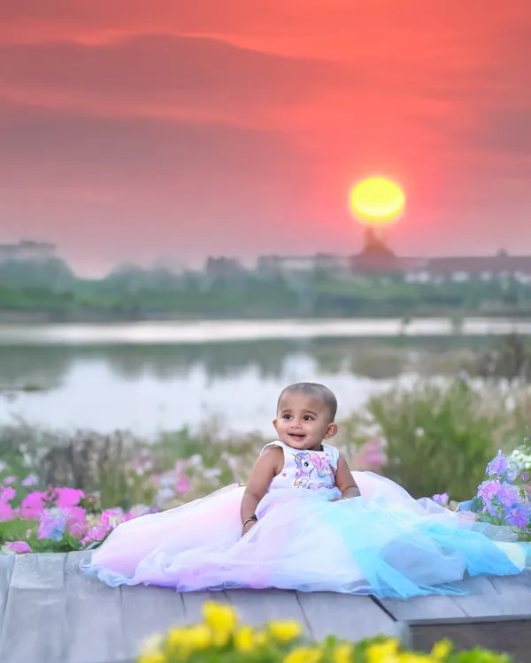 This outdoor portrait was taken during the magical golden hour. The warm sunset over the lake creates a stunning, colourful backdrop for this little girl in her beautiful pastel dress.