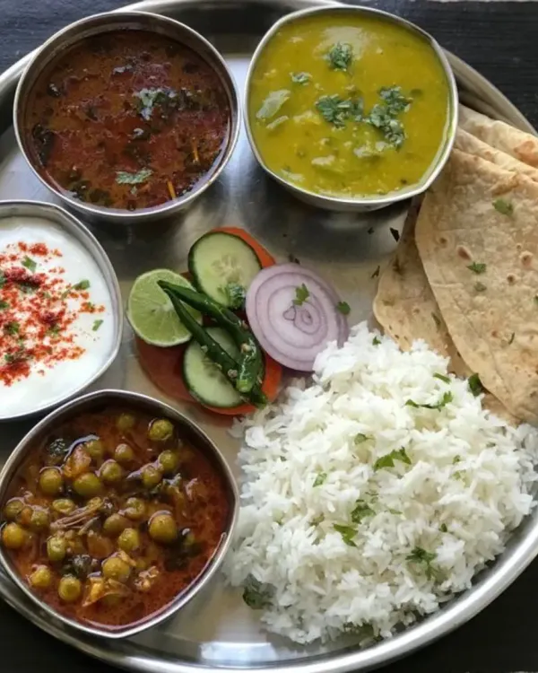 A glimpse of the soulful comfort I serve. This thali features a balanced spread of matar sabzi, dal, steamed rice, fresh salad, creamy raita, and soft rotis, all prepared with simple ingredients and a lot of love.