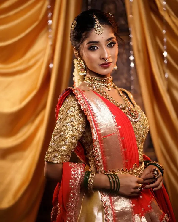 A classic South Indian muhurtham bridal look, featuring a radiant HD makeup base that complements the traditional gold and red silk saree. The focus is on creating a timeless, glowing complexion perfect for wedding photography.