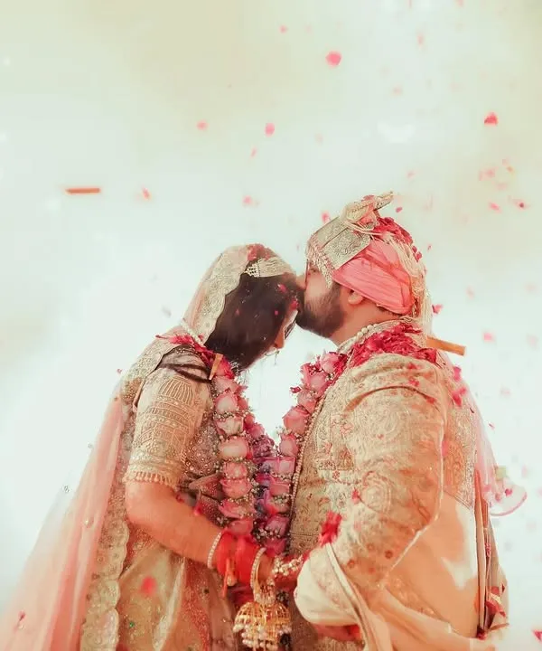 A magical moment as the couple kisses, surrounded by a shower of petals and the glow of fireworks. This is the kind of grand, cinematic shot we love to create.