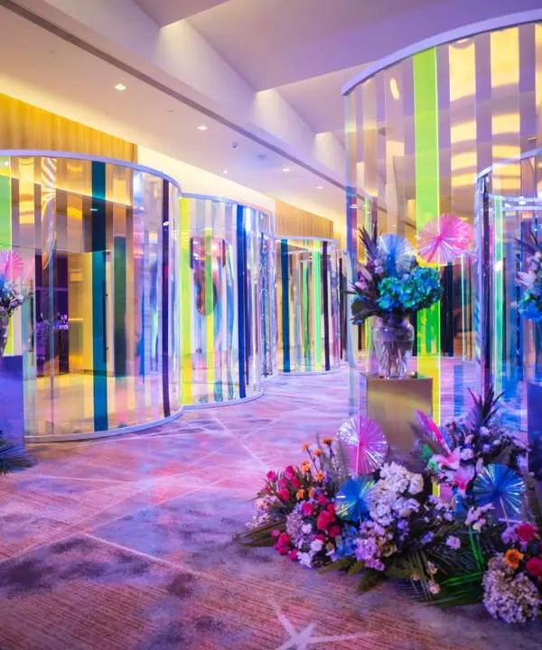 The entrance to the sangeet, where guests journeyed through a mesmerizing tunnel of iridescent panels and vibrant floral arrangements. This set the stage for a night of modern elegance and high energy celebration.