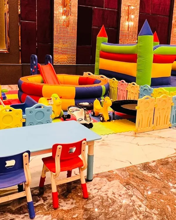 A complete soft play zone for toddlers, featuring a ball pit, slides, a bouncy castle, and kid-sized tables and chairs.