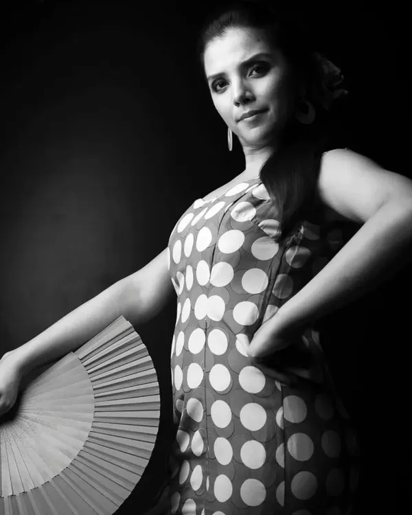 To me, dance is a divine conversation, especially when sharing it with an audience that hangs on every movement. This black and white portrait captures a moment of connection, holding a traditional fan or 'abanico'. I believe in planting the seeds of artistic possibility, and I bring this passion for performance and authenticity into every class I teach.