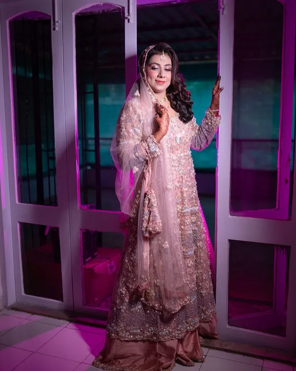A beautiful full-length shot of my Walima bride. The soft pink, heavily embellished gown is paired with elegant makeup and side-swept curls for a glamorous reception look.
