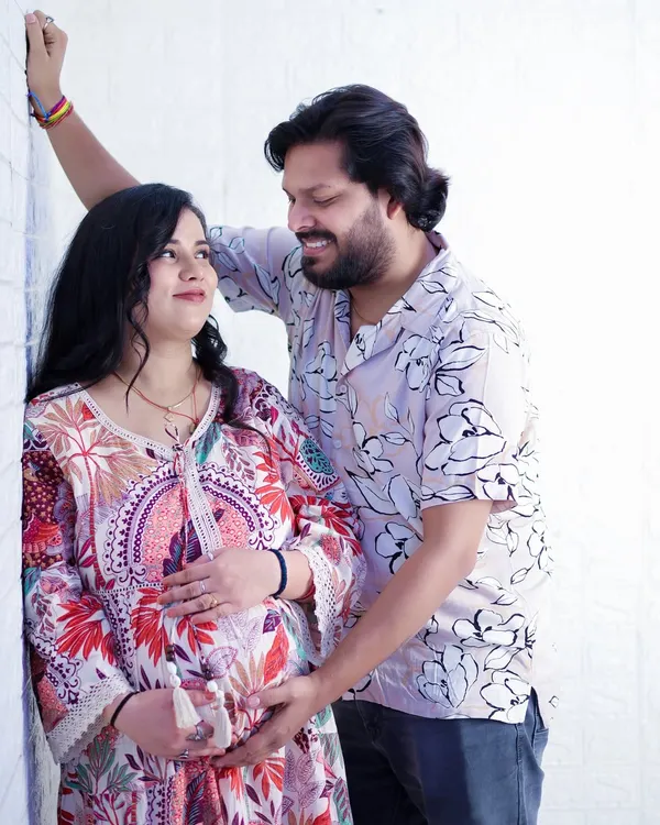 A candid and loving moment between an expecting couple. The genuine smiles and gentle touch on the baby bump make this a timeless memory of their shared excitement.