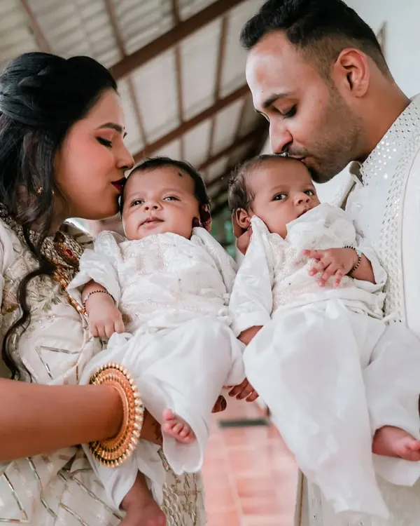 A heartwarming portrait of new parents holding their twin babies, a perfect capture of love and family.