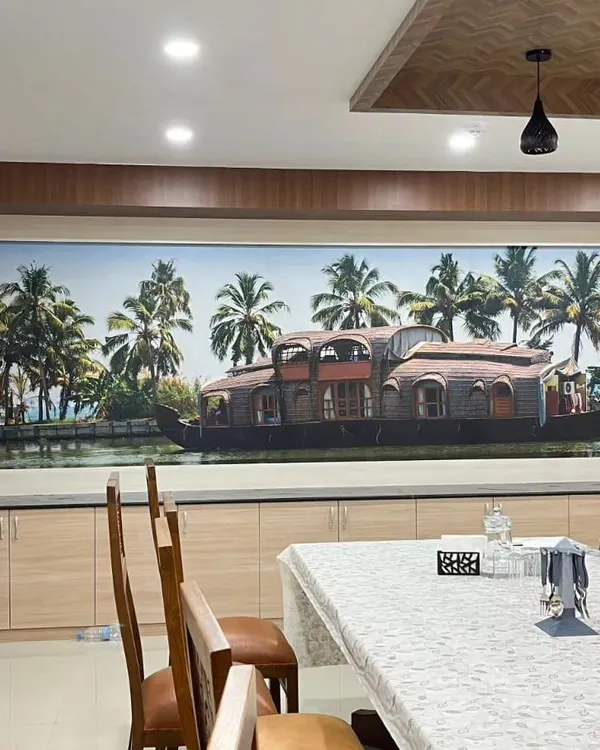 I brought the beauty of the Kerala backwaters into this dining room with a custom scenic mural. The image of a traditional houseboat creates a peaceful and culturally rich atmosphere for family meals.