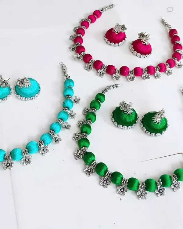 When a customer wants the colors of Holi beaded in hand-fixed necklaces. These silk thread sets in pink, teal, and green were created as custom return gifts.