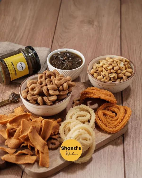 A beautiful snack board featuring a variety of my handmade items. You can see the textures of the ribbon pakoda, different murukkus, kodbale, and peanuts, perfect for serving with my homemade chutney.