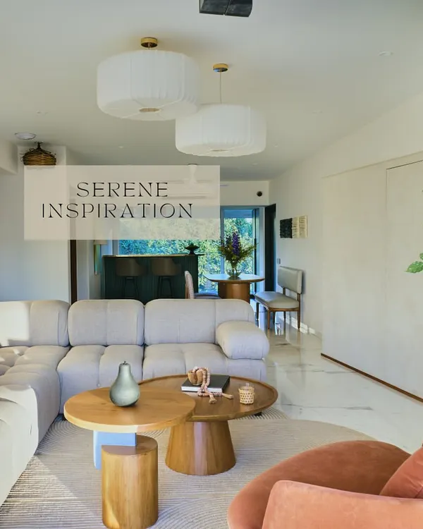 The open-plan living space in 'House on the Hill' is designed for serenity and flow. A plush, light-colored sectional sofa and nested wooden coffee tables create a comfortable gathering spot, all bathed in natural light.